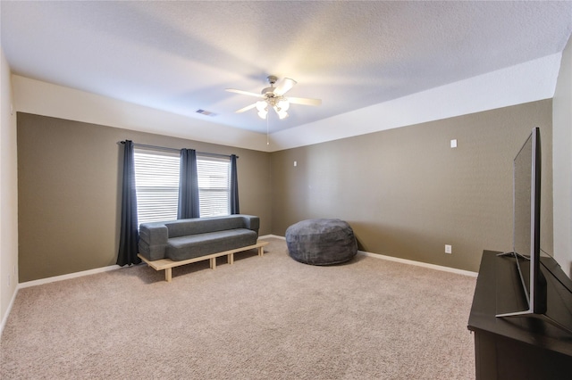living area with carpet, visible vents, baseboards, and ceiling fan