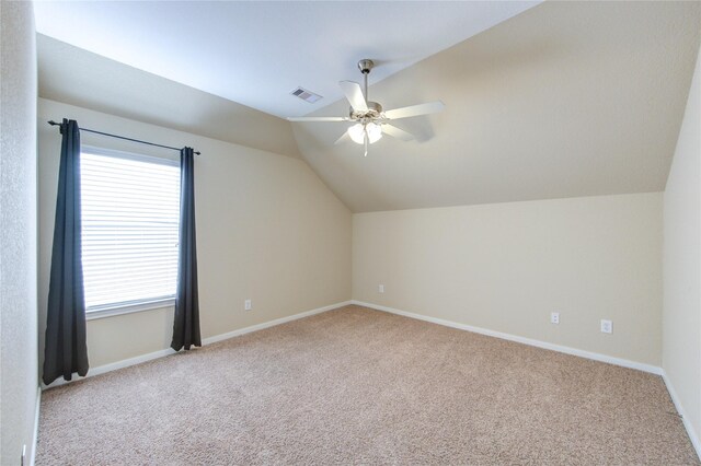 additional living space featuring visible vents, baseboards, a ceiling fan, vaulted ceiling, and carpet flooring