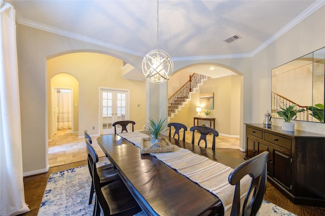 dining area featuring visible vents, baseboards, arched walkways, stairway, and french doors