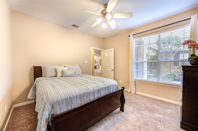 bedroom featuring light carpet, baseboards, multiple windows, and visible vents
