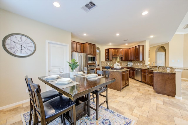 dining space featuring recessed lighting, arched walkways, visible vents, and baseboards