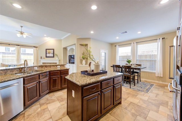 kitchen featuring a healthy amount of sunlight, dishwasher, a sink, and visible vents
