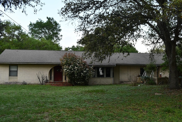 ranch-style house featuring a front yard and brick siding