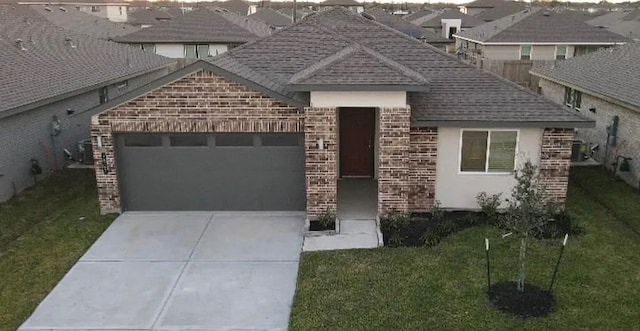 view of front of property featuring concrete driveway, a front yard, brick siding, a garage, and a shingled roof