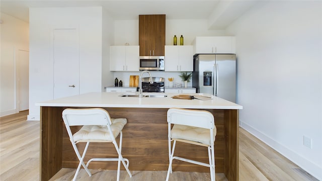 9616 Habitat St, Houston, TX 77075 - kitchen featuring a sink, a kitchen island with sink, light countertops, a kitchen bar, and appliances with stainless steel finishes