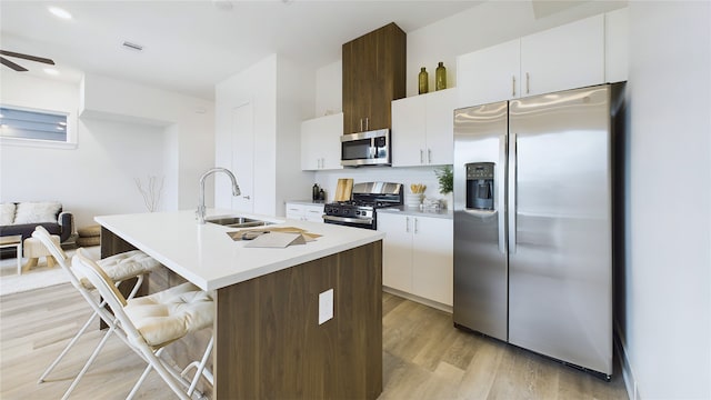 9616 Habitat St, Houston, TX 77075 - kitchen featuring a sink, light wood-style floors, a center island with sink, appliances with stainless steel finishes, and a breakfast bar area