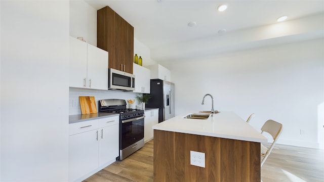 9628 Habitat St, Houston, TX 77075 - kitchen featuring a sink, decorative backsplash, an island with sink, stainless steel appliances, and light wood finished floors