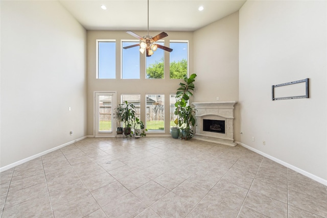 2230 Dali Ln, Missouri City, TX 77459 - unfurnished living room featuring ceiling fan, light tile patterned flooring, baseboards, and a high end fireplace