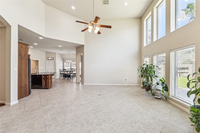 2230 Dali Ln, Missouri City, TX 77459 - unfurnished living room featuring arched walkways, ceiling fan with notable chandelier, baseboards, and recessed lighting