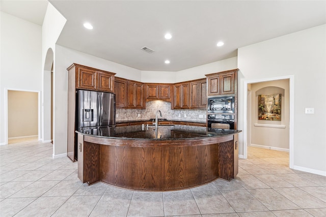 2230 Dali Ln, Missouri City, TX 77459 - kitchen featuring visible vents, a sink, black appliances, a spacious island, and backsplash