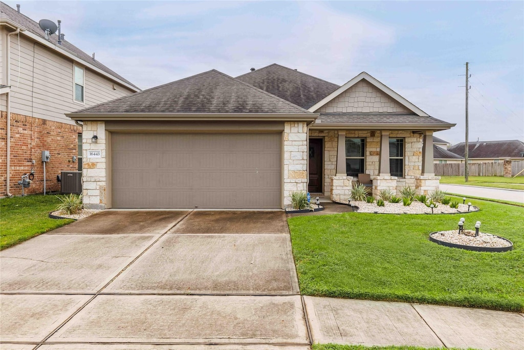 16443 Regal Exeter Dr, Houston, TX 77073 - ranch-style house with roof with shingles, stone siding, a front lawn, an attached garage, and driveway