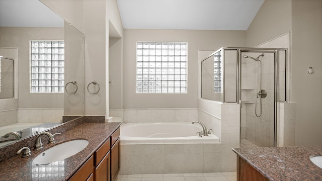 bathroom with a bath, vaulted ceiling, vanity, and a shower stall