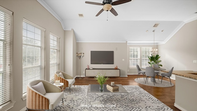 living area with a wealth of natural light, crown molding, dark wood-type flooring, and visible vents