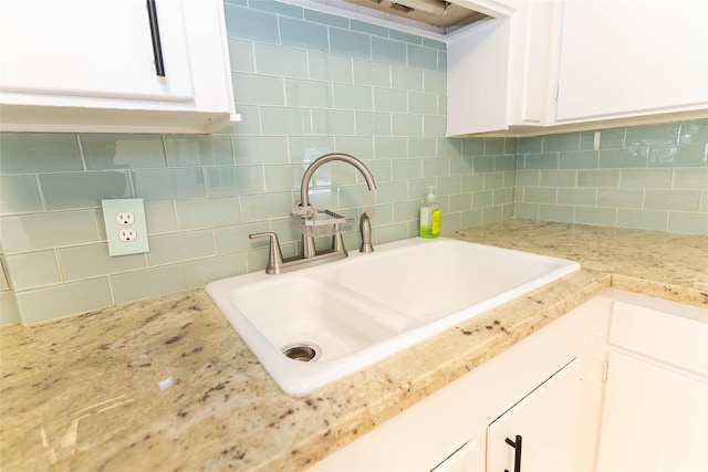 2315 Poinciana Dr, Houston, TX 77018 - kitchen with white cabinetry, backsplash, light stone countertops, and a sink