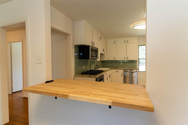 2315 Poinciana Dr, Houston, TX 77018 - kitchen featuring white cabinets, backsplash, stainless steel appliances, and butcher block counters