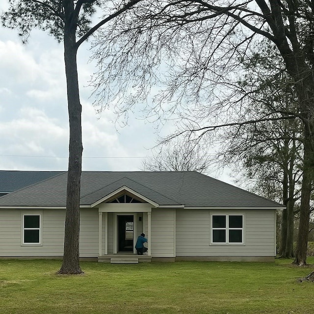 ranch-style house with a shingled roof and a front yard