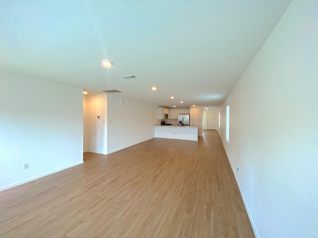 21015 Longeni Dr, New Caney, TX 77357 - unfurnished living room featuring light wood finished floors, baseboards, and recessed lighting