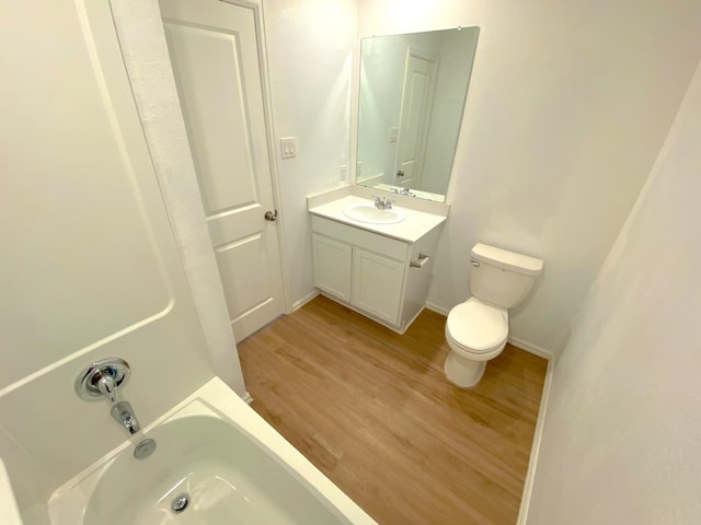 21015 Longeni Dr, New Caney, TX 77357 - bathroom with toilet, wood finished floors, vanity, baseboards, and shower / washtub combination