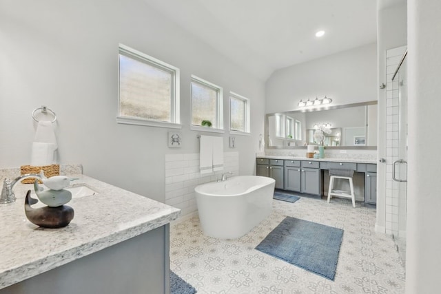 250 Peninsula Point Dr, Montgomery, TX 77356 - bathroom featuring two vanities, a freestanding bath, tile walls, a shower stall, and vaulted ceiling