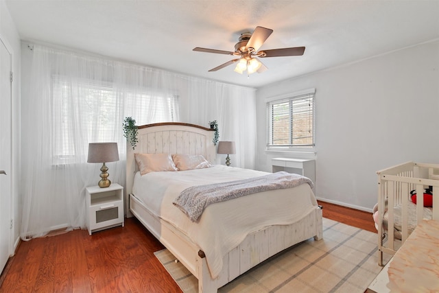 bedroom with wood finished floors, baseboards, and ceiling fan