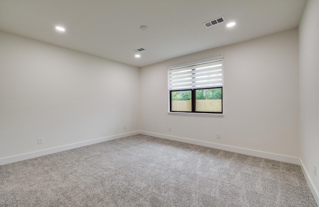 carpeted spare room featuring baseboards, recessed lighting, and visible vents