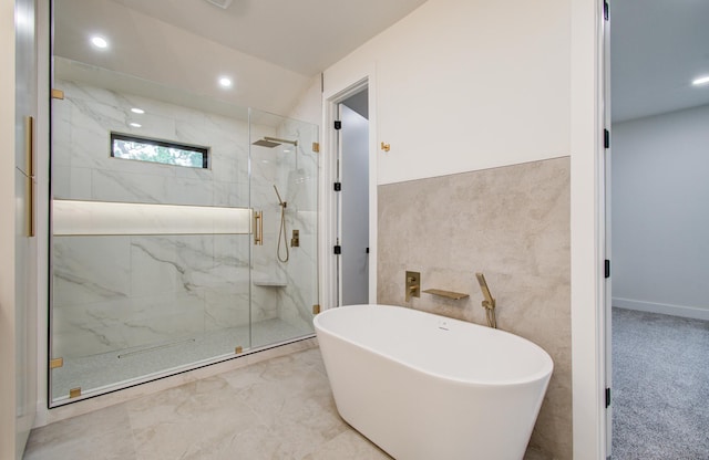 full bath with a marble finish shower, a soaking tub, recessed lighting, and tile walls