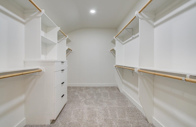 spacious closet featuring vaulted ceiling and light carpet