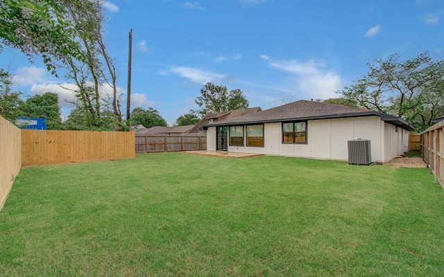 back of property featuring a fenced backyard, a shingled roof, a patio area, a lawn, and central air condition unit