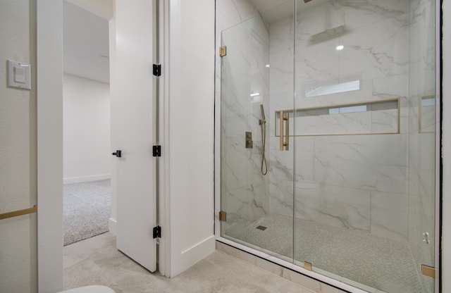bathroom featuring baseboards and a marble finish shower