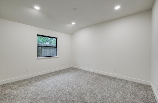 spare room with vaulted ceiling, baseboards, carpet flooring, and recessed lighting