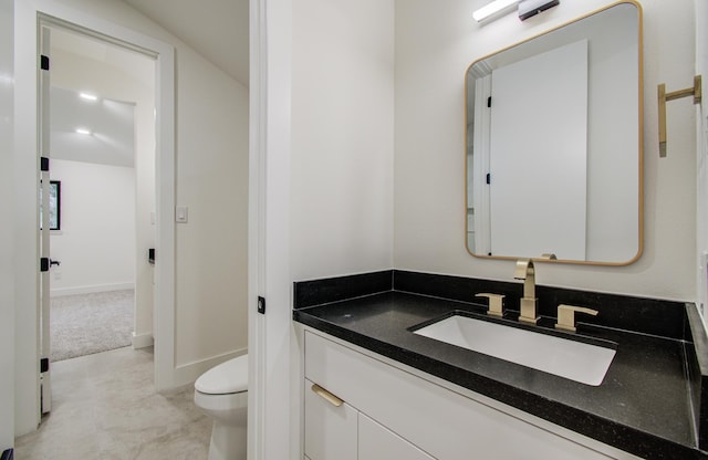 half bath featuring toilet and vanity