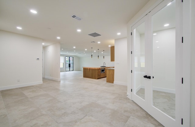 corridor featuring a sink, baseboards, recessed lighting, and visible vents