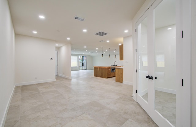 hallway featuring baseboards, recessed lighting, and visible vents