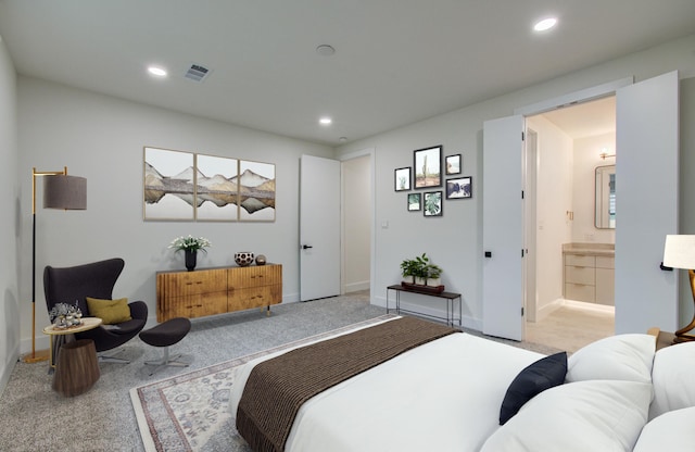 carpeted bedroom with connected bathroom, recessed lighting, baseboards, and visible vents