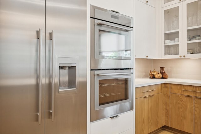 739 Azaleadell Dr, Houston, TX 77018 - kitchen featuring glass insert cabinets, appliances with stainless steel finishes, light countertops, and decorative backsplash