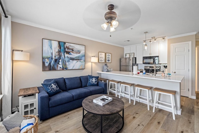9520 Seawall Blvd Unit 254, Galveston, TX 77554 - living area featuring a ceiling fan, ornamental molding, and light wood-style flooring
