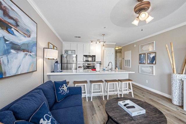 9520 Seawall Blvd Unit 254, Galveston, TX 77554 - living area featuring light wood-style floors, crown molding, a ceiling fan, and baseboards