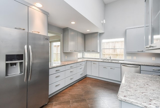 2918 Manila Ln, Houston, TX 77043 - kitchen with appliances with stainless steel finishes, a sink, gray cabinetry, light stone counters, and recessed lighting