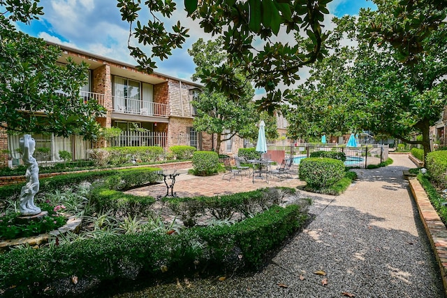 view of home's community with fence and a patio