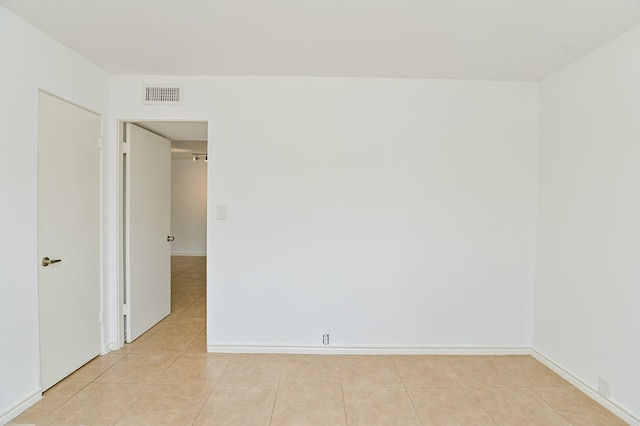 unfurnished room with light tile patterned flooring, baseboards, and visible vents