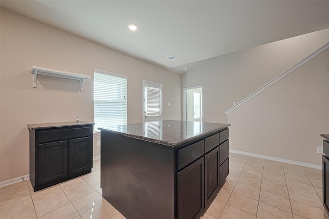 2402 Ivory Ct, Texas City, TX 77591 - kitchen featuring open shelves, a center island, light tile patterned floors, baseboards, and dark stone counters