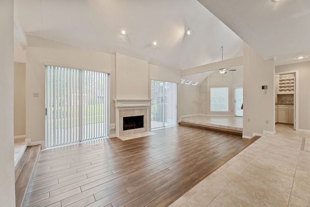 3708 Masters Ct, League City, TX 77573 - unfurnished living room featuring a ceiling fan, a fireplace, light wood-style flooring, lofted ceiling, and baseboards