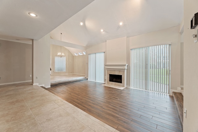 3708 Masters Ct, League City, TX 77573 - unfurnished living room with a chandelier, a tile fireplace, wood finished floors, baseboards, and high vaulted ceiling