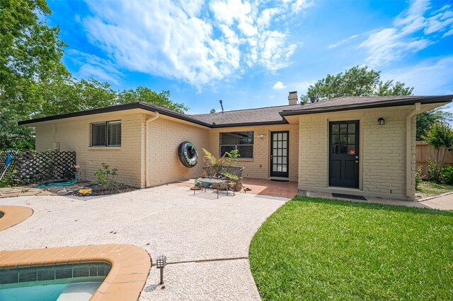 rear view of house with fence, a chimney, a patio, and brick siding