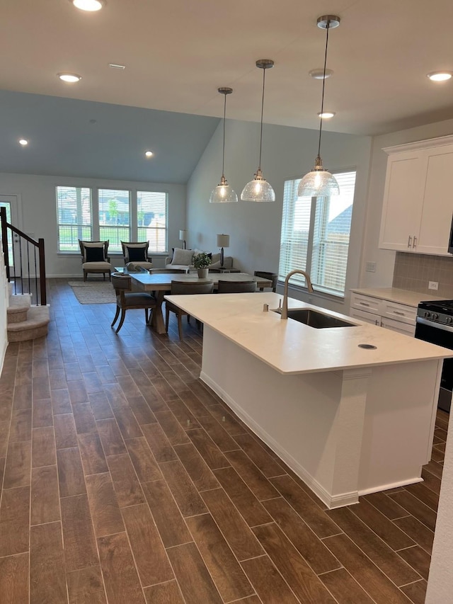 26767 Grandiflora Dr, Magnolia, TX 77355 - kitchen featuring a sink, black gas stove, wood tiled floor, white cabinetry, and a center island with sink