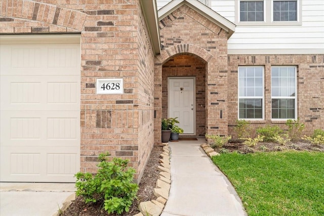 doorway to property featuring brick siding