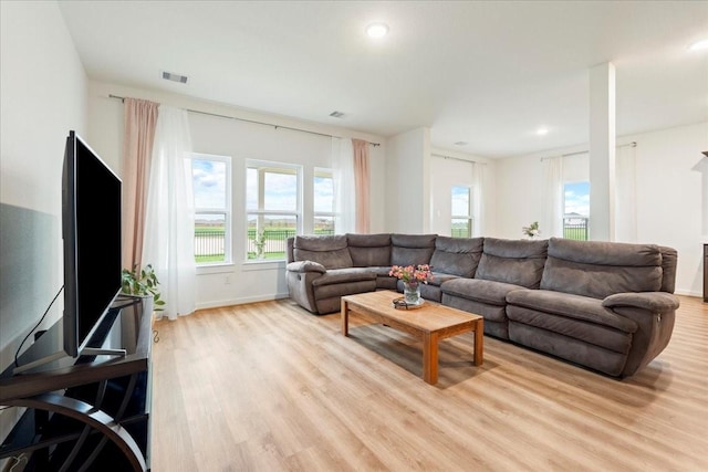 living area with baseboards, light wood-style flooring, visible vents, and recessed lighting