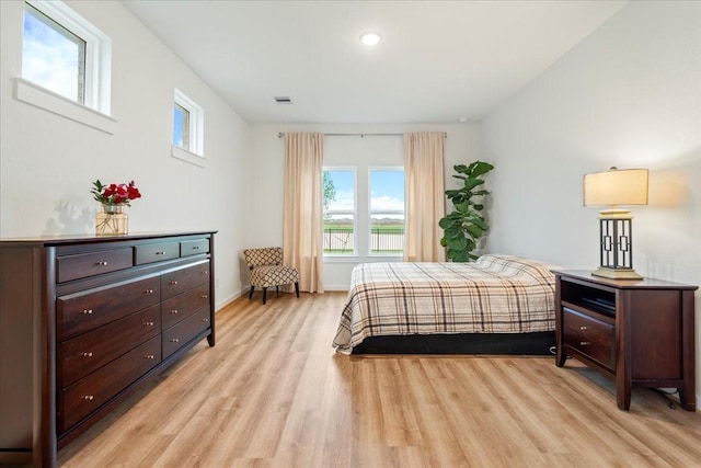 bedroom featuring baseboards, light wood finished floors, and visible vents