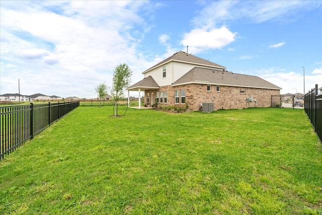 exterior space with cooling unit, a fenced backyard, and a yard