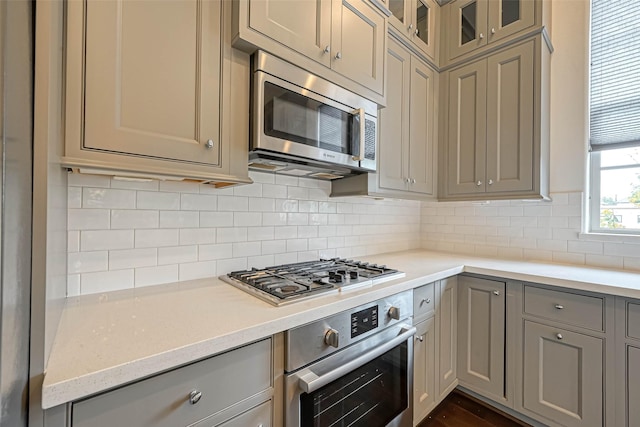 5101 Allen St, Houston, TX 77007 - kitchen with stainless steel appliances, gray cabinets, light countertops, backsplash, and glass insert cabinets